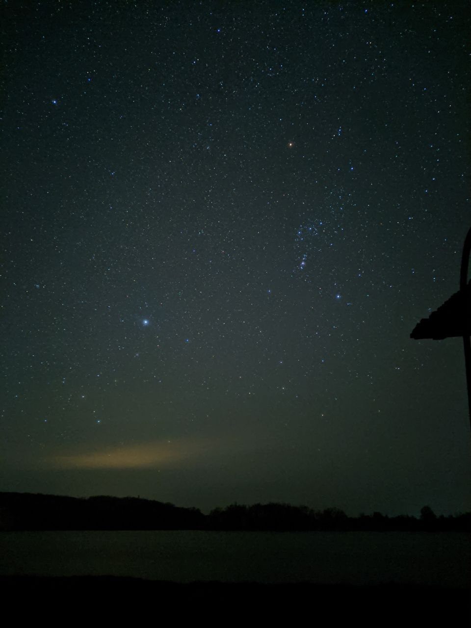 a starry night sky over a field
